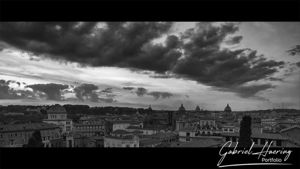 Black and white skyline of Rome under dramatic clouds